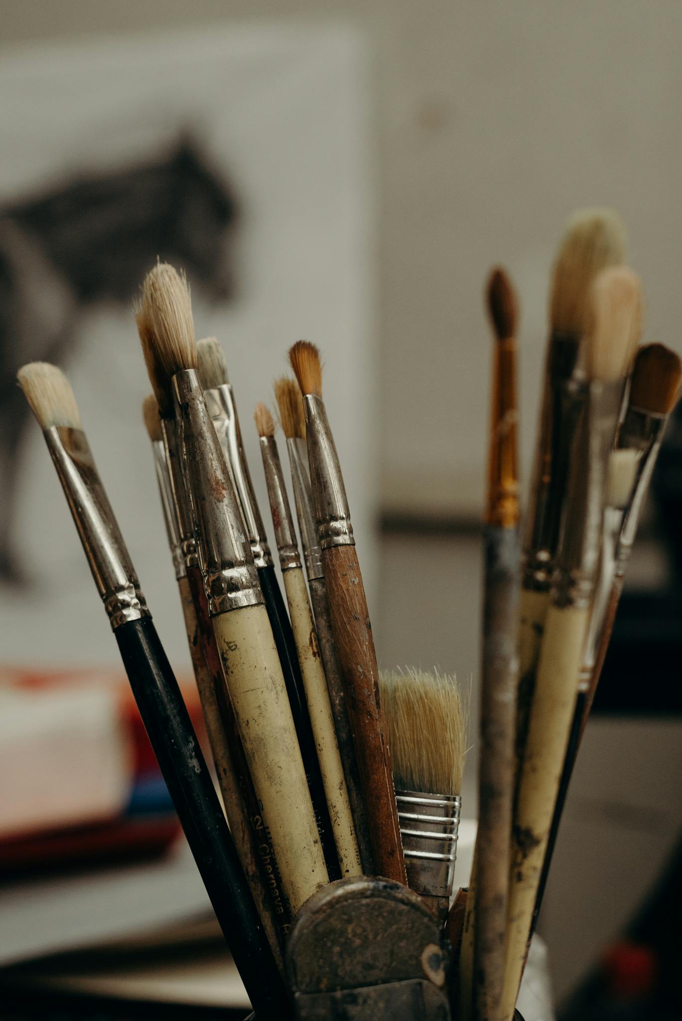 A collection of used paintbrushes in an artist's studio with creative energy evident.