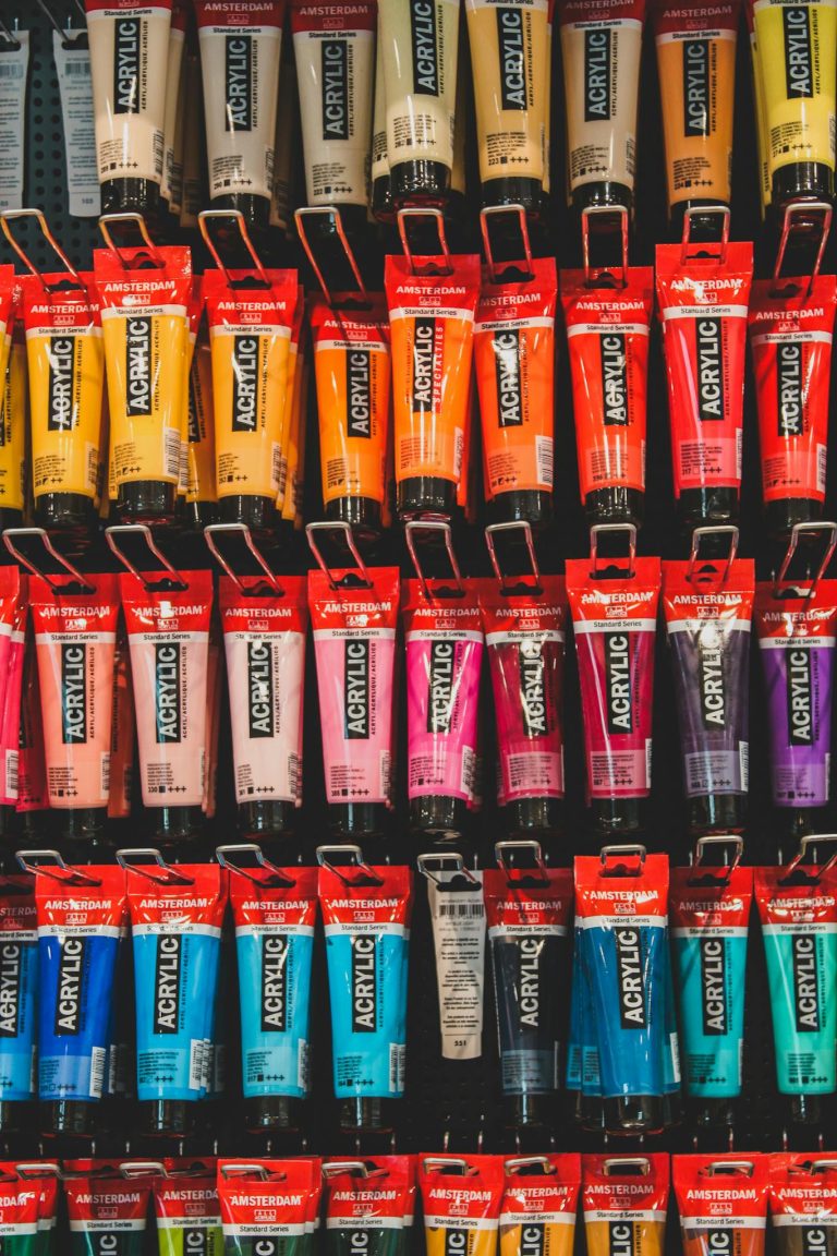 A vibrant array of acrylic paint tubes arranged neatly on a shelf.